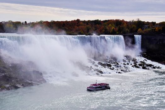 A breathtaking view of Niagara Falls with a tour boat navigating the waters below.