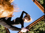 一个女人的艺术肖像反映在镜子里的天空中，创造了一个引人入胜的视觉转折