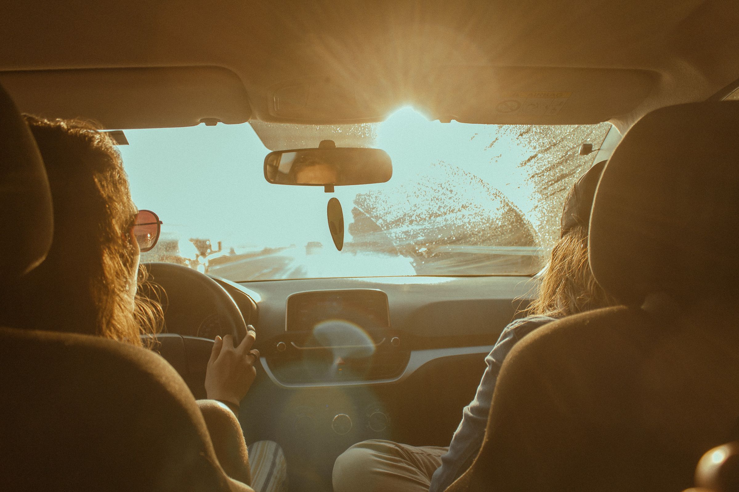 Harsh summer sun streaming through a car windshield onto a hot interior cabin