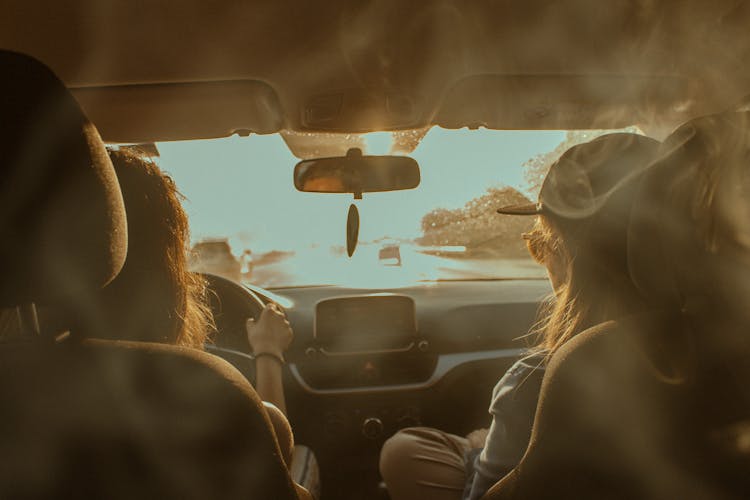 Women Driving Car On Sunny Road