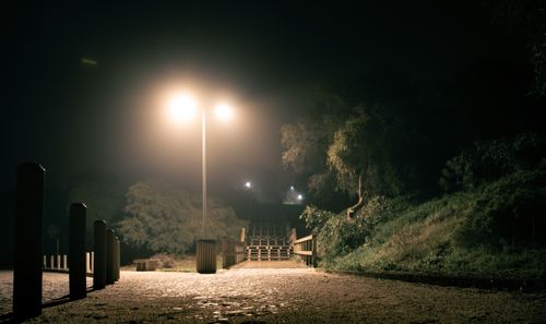 Free Peaceful night scene in a park, featuring illuminated walkway and streetlight, enhancing a tranquil atmosphere. Stock Photo