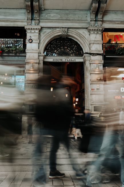 Dynamic urban scene capturing blurred pedestrians against Istanbul's historic Suriye Passage.
