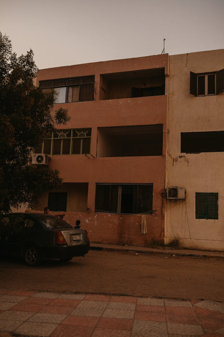 Black Car Parked Beside Brown Concrete Building