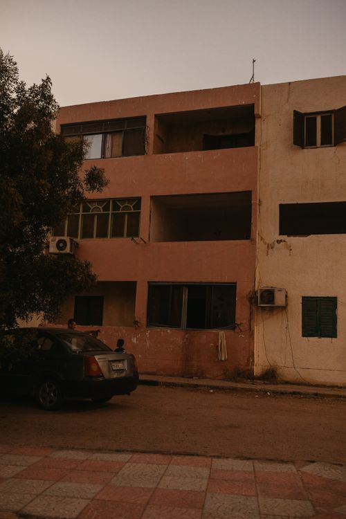 Free A parked car in front of a rustic building on a street in Egypt, during daytime. Stock Photo