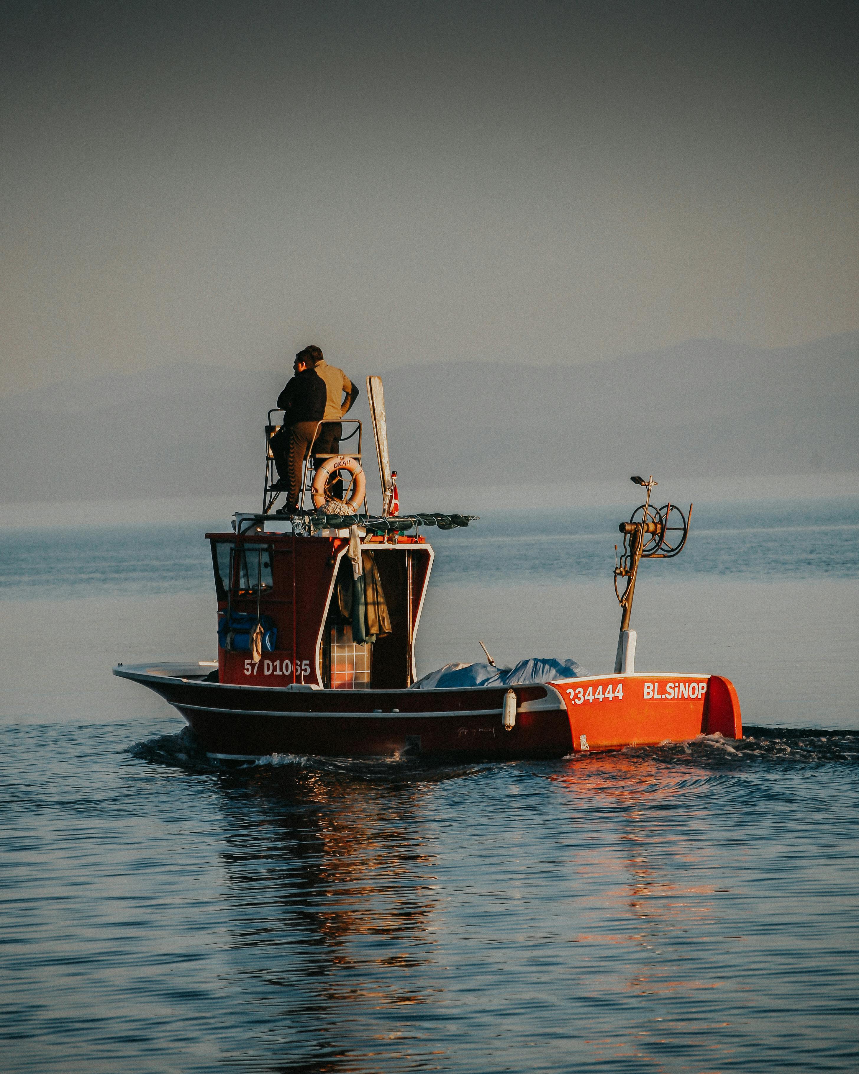 A Fishing Boat On Water With People At Early Sunrise · Free Stock Photo