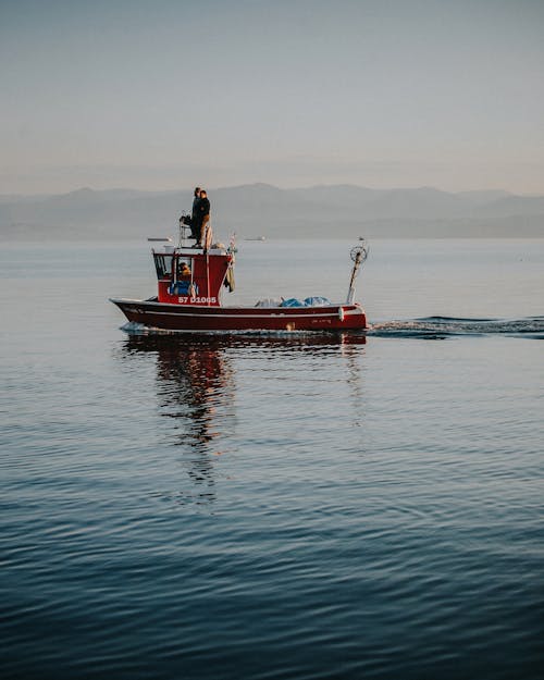 People on Small Fishing Boat Sailing on Lake