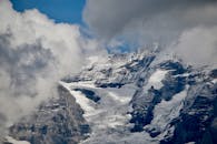 瑞士阿尔卑斯山白雪覆盖的山峰和冰川壮丽非凡，四周云层环绕