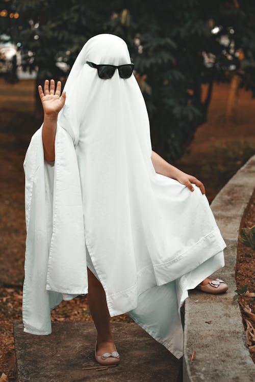 A  Person in White Spooky Costume Standing on Grass Field