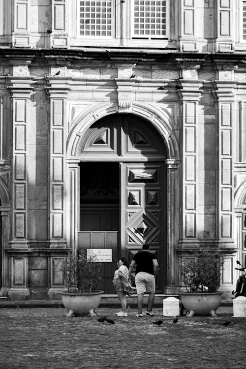 Black and White Photo of People in Front of Monumental Building Entrance