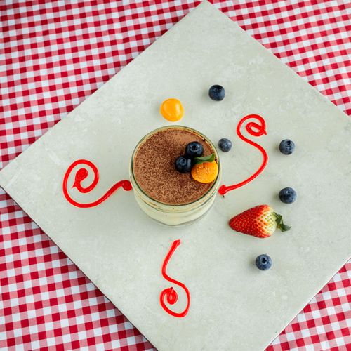 Free Top view of a mousse dessert garnished with fresh berries on a gingham tablecloth. Stock Photo
