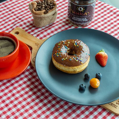 Free Chocolate donut with coffee and fruits on a checkered tablecloth, perfect breakfast setup. Stock Photo