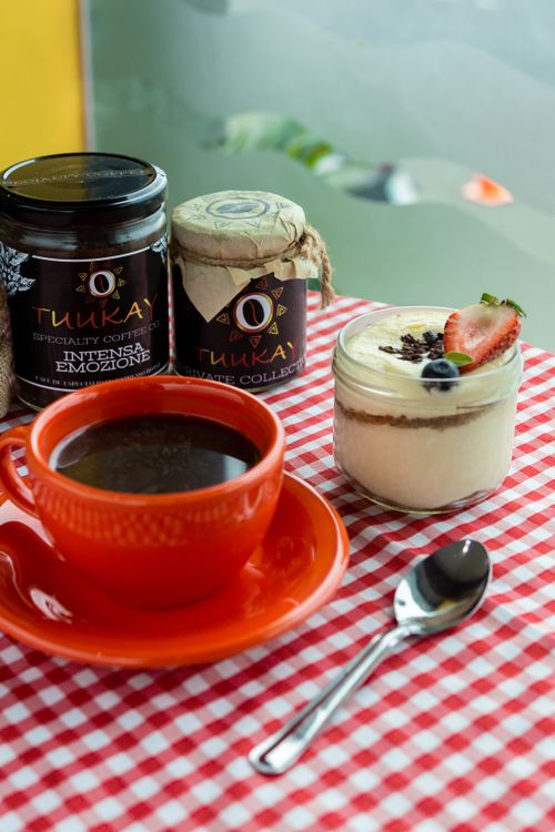 Free Cup of coffee with dessert and coffee jars on a red checkered tablecloth. Stock Photo