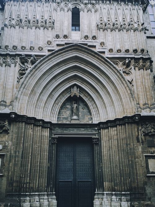 Free Majestic gothic cathedral entrance featuring intricate arches and detailed stonework. Stock Photo