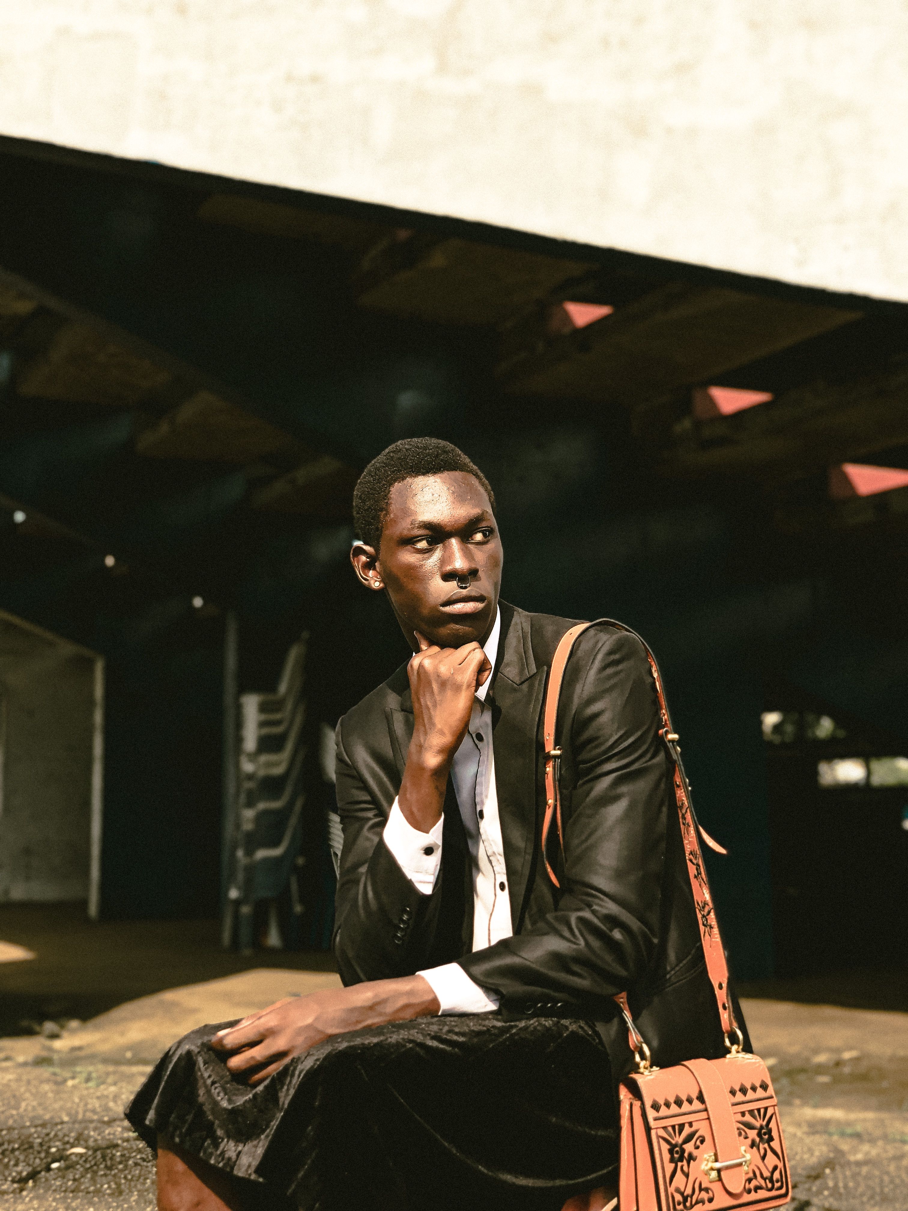 Portrait of an African man sitting in an urban setting, dressed in a suit.