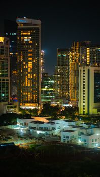 A dazzling city skyline at night with towering skyscrapers and vivid lights illuminating the scene.