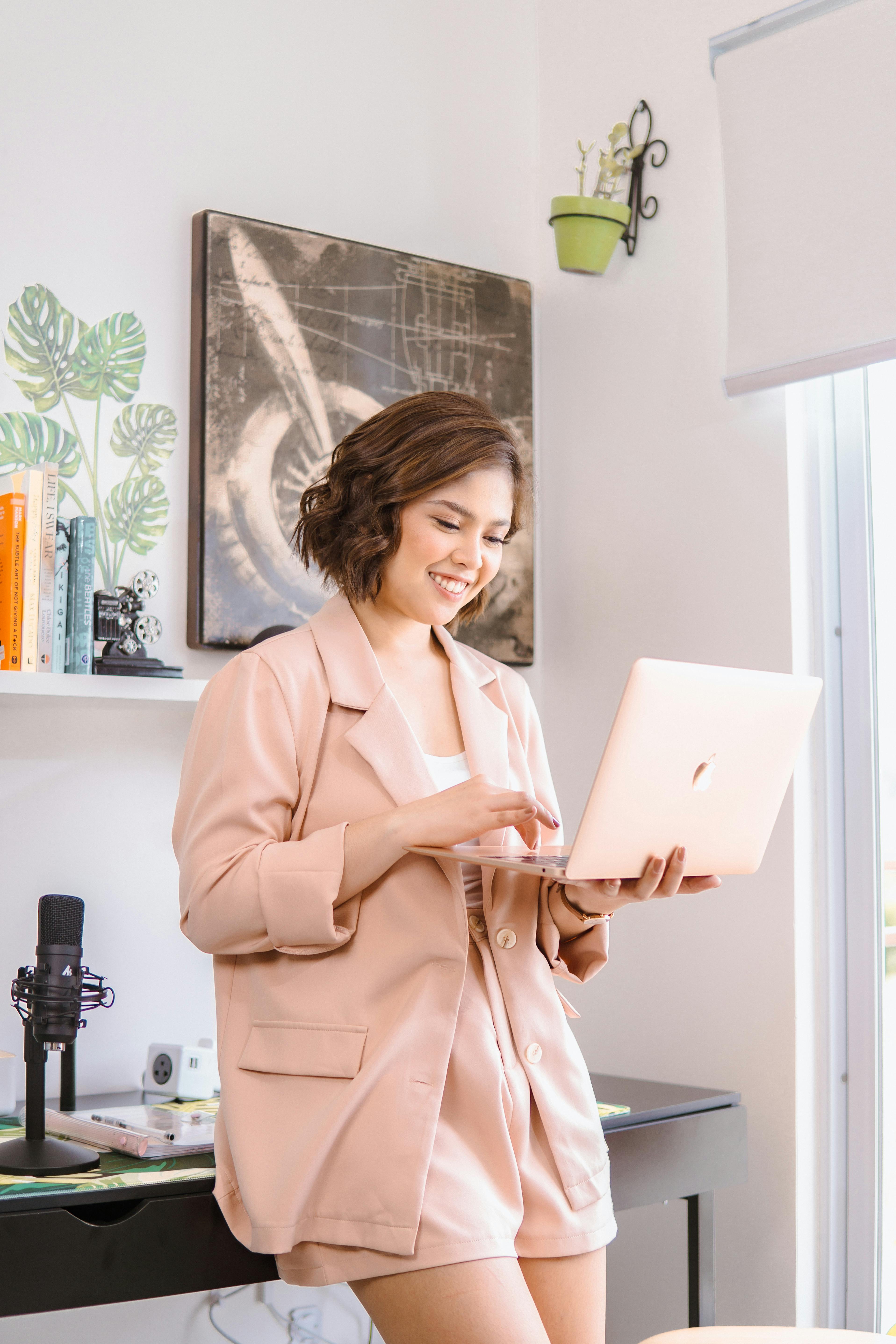 woman in coat with laptop in room