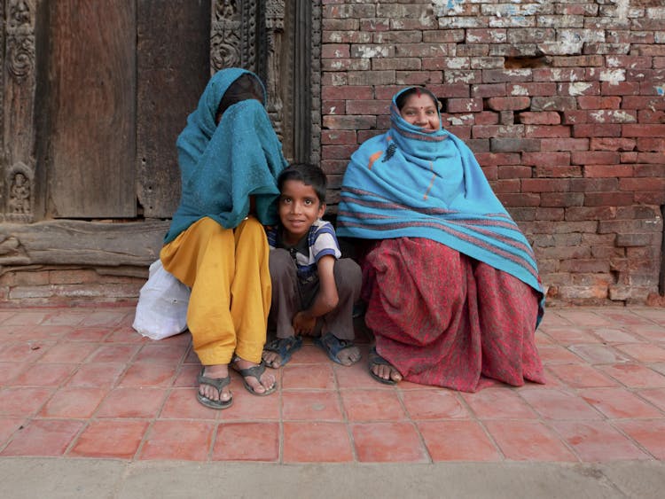 Woman And Child Sitting On Street