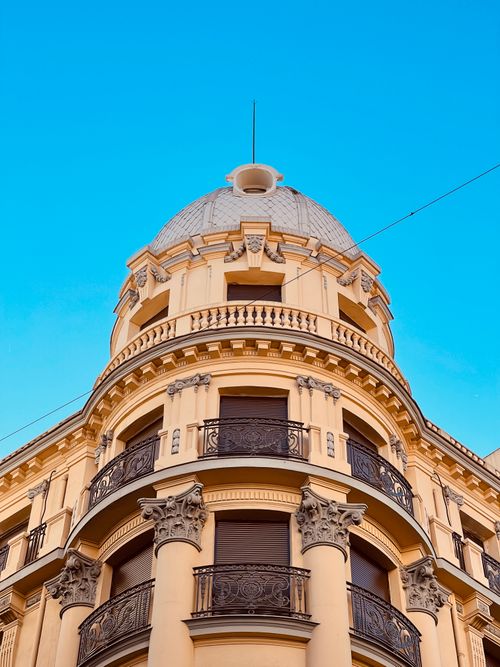Free Low angle view of an elegant domed building with intricate railings against a clear blue sky. Stock Photo