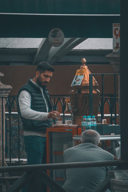 Man Serving Coffee in Traditional Cafe