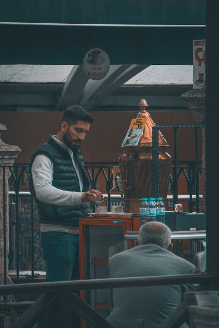 Man Serving Coffee In Traditional Cafe