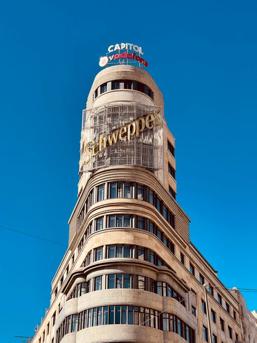 Free Low angle view of the Capitol building featuring the famous Schweppes sign against a clear blue sky in Madrid. Stock Photo