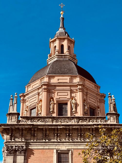 Free A historic baroque church tower captured from a low angle against a blue sky. Stock Photo