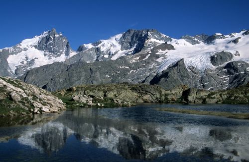 Free Scenic view of snow-covered mountains and lake reflection in La Grave, France. Stock Photo