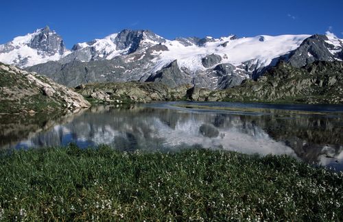 Free Majestic snow-capped mountains and a serene lake reflection in La Grave, France. Stock Photo