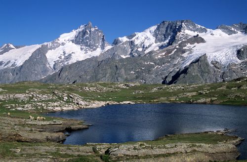 Free Beautiful Alpine lake with snowy mountains in La Grave, France, a perfect nature escape. Stock Photo