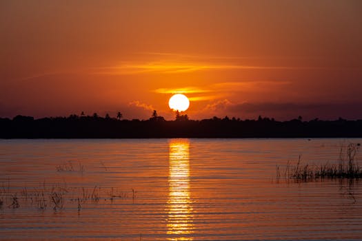 Stunning sunset at Jericoacoara lagoon with vivid reflections on the water, a perfect serene landscape.
