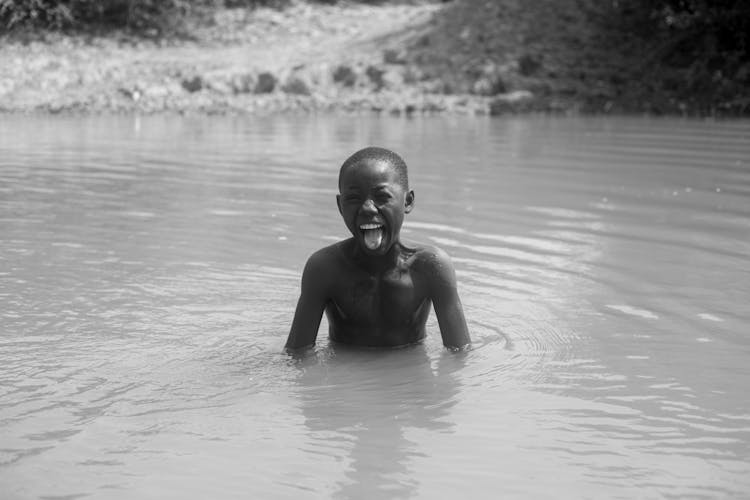 Shirtless Boy Swimming In A River