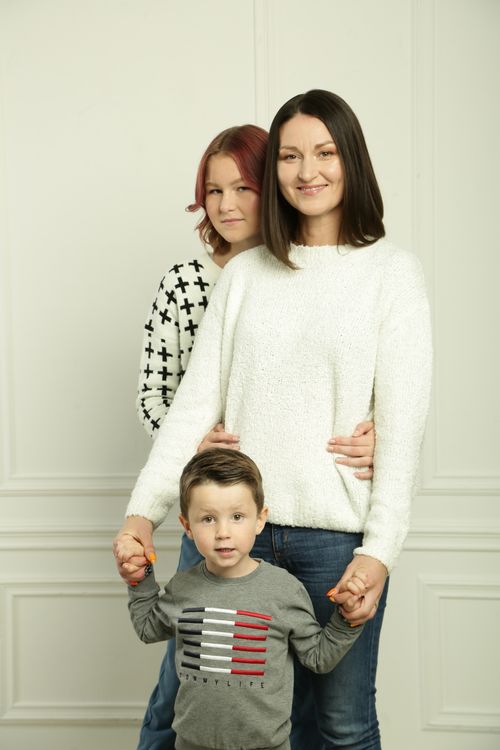Free A joyful family portrait with two women and a young boy holding hands. Stock Photo