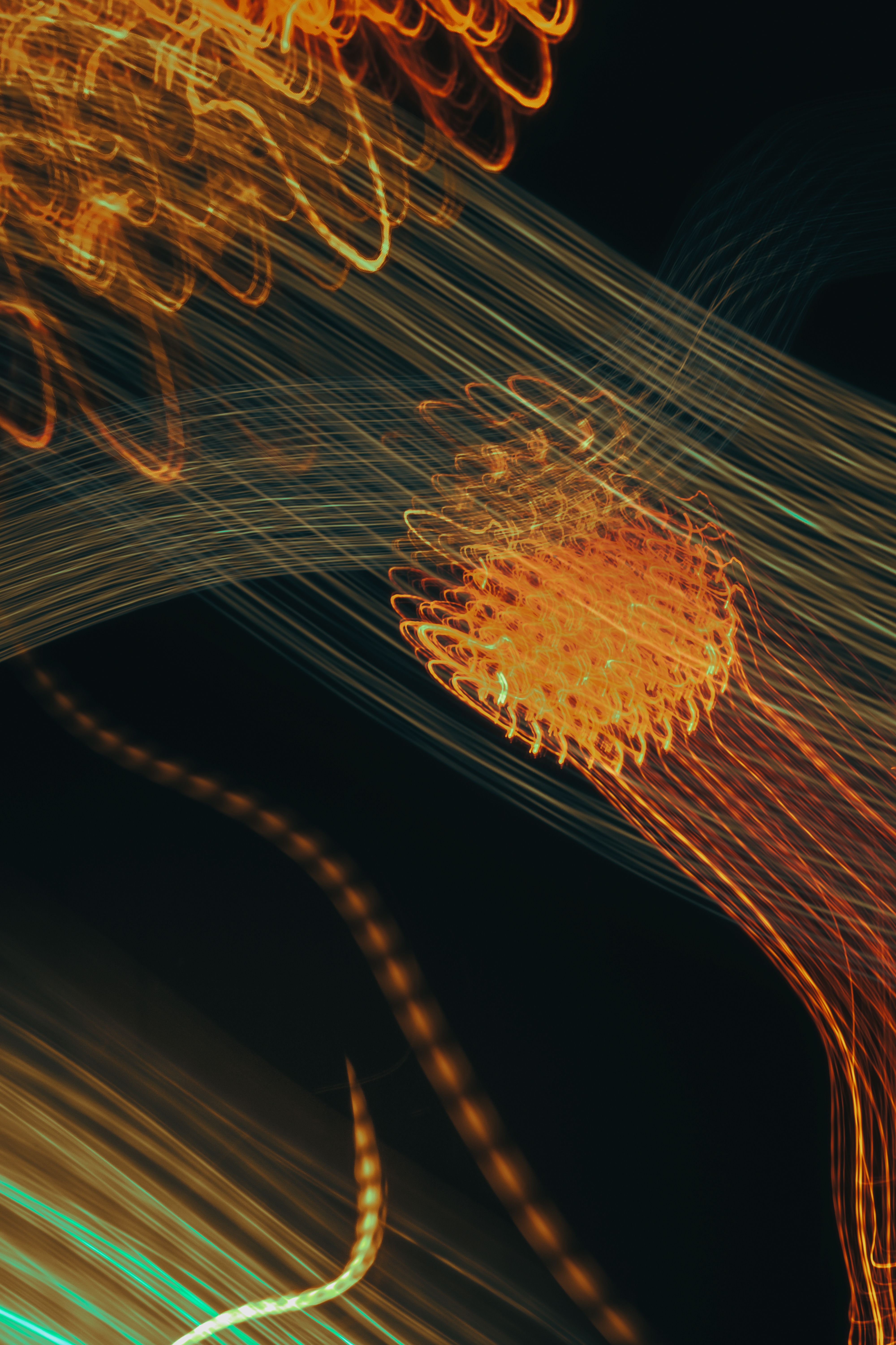 Dynamic abstract light trails creating vibrant patterns with a dark background.