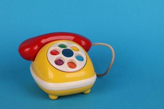 Close-up of a retro colorful toy telephone against a vibrant blue background.