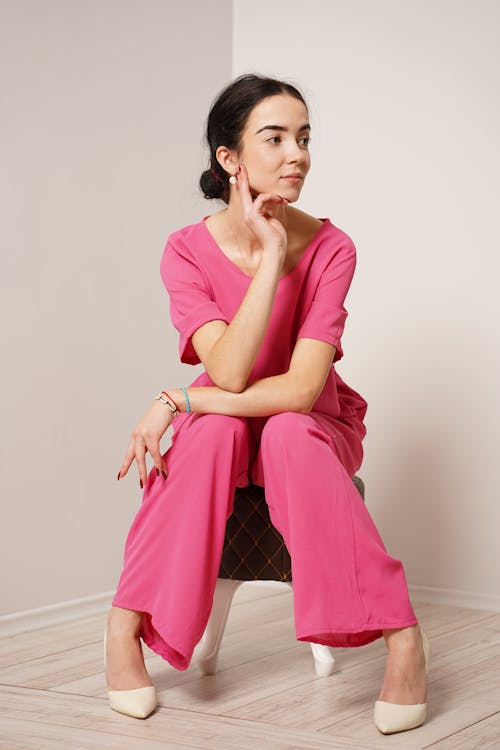 Free Woman in Pink Dress Sitting on White Chair Stock Photo