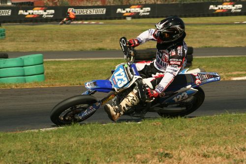 Free Dynamic action shot of a motocross rider leaning into a sharp turn on a race track, showcasing speed and skill. Stock Photo