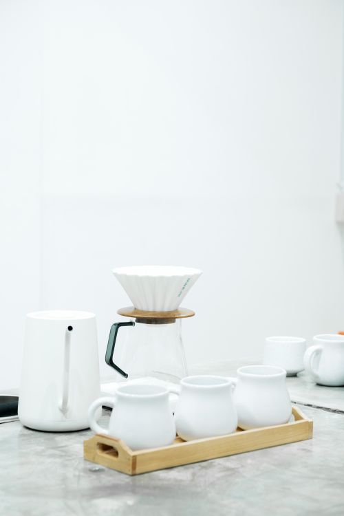 Free A clean and elegant setup for coffee brewing with white porcelain cups and a dripper. Stock Photo