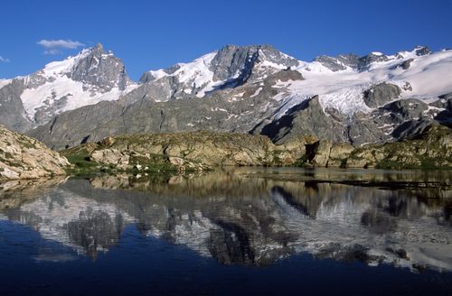 Free Serene alpine lake with rocky reflections in La Grave, France. Stock Photo