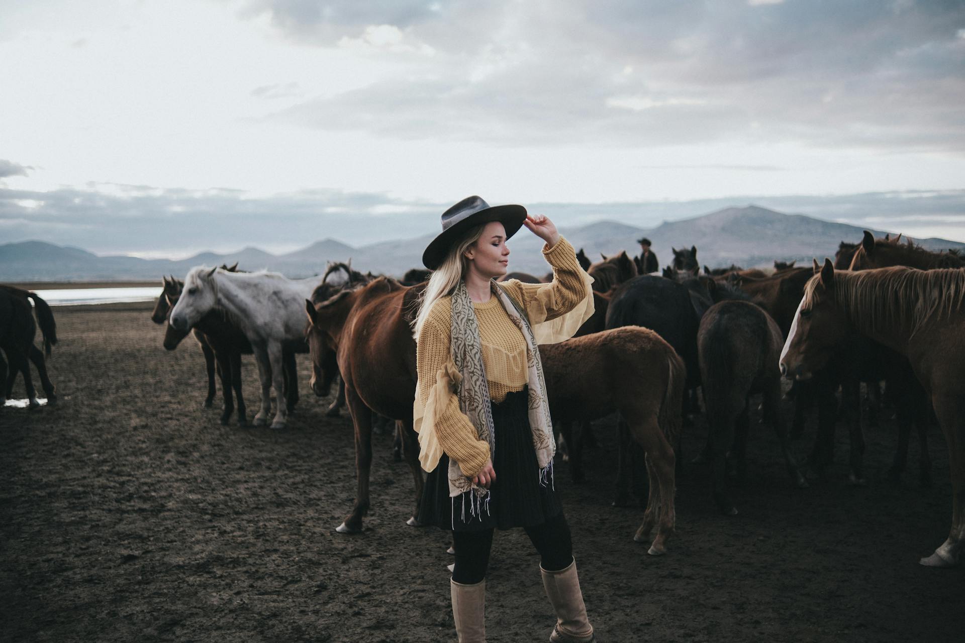 Blonde Woman in Hat among Horses