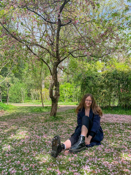 A Woman Sitting on the Grass Field Under a Tree