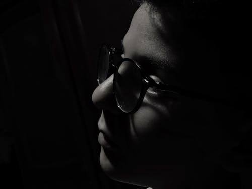 Grayscale Photo of Boy Wearing Eyeglasses in Close Up Photography