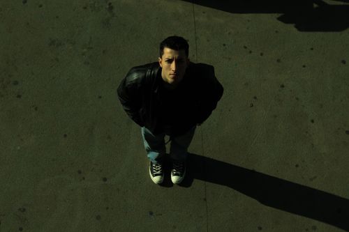 Free Man in a black leather jacket and sneakers on a street, viewed from above. Stock Photo