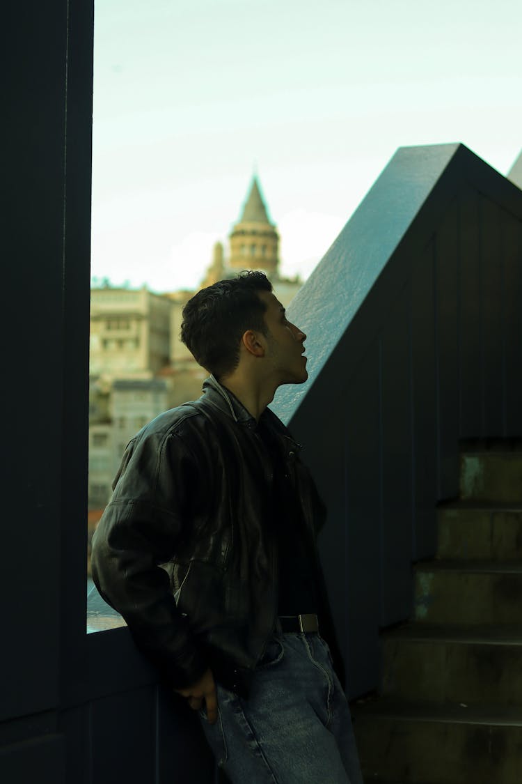 Man Wearing A Black Leather Jacket Standing On Stairs