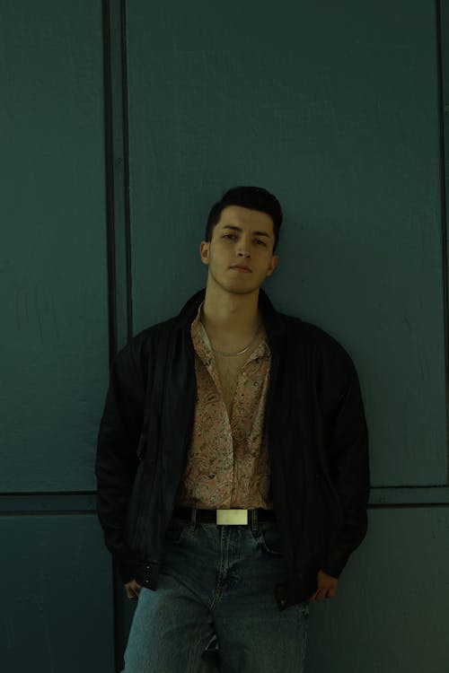 Man in Black Jacket Standing Near Dark Green Wall