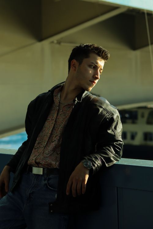 Free A fashionable young man with short hair poses confidently outdoors in a casual outfit. Stock Photo