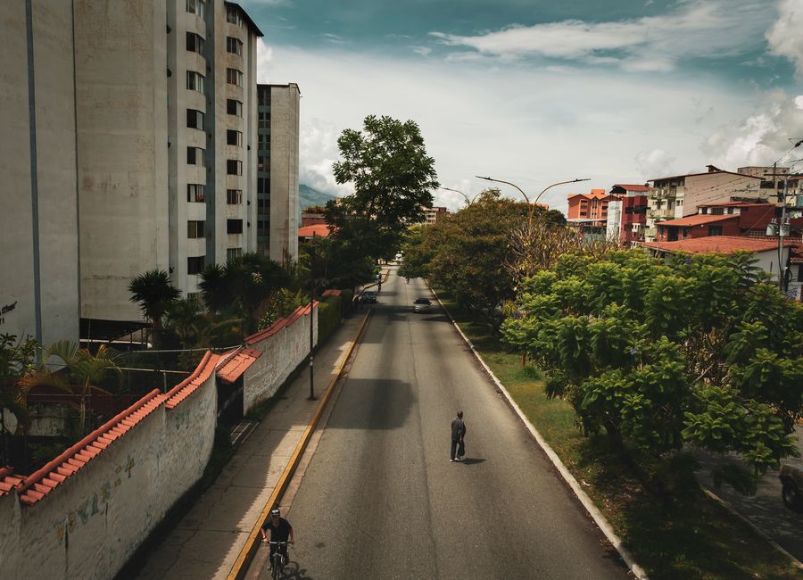 Quiet urban street in Mérida, Venezuela with trees lining the road.