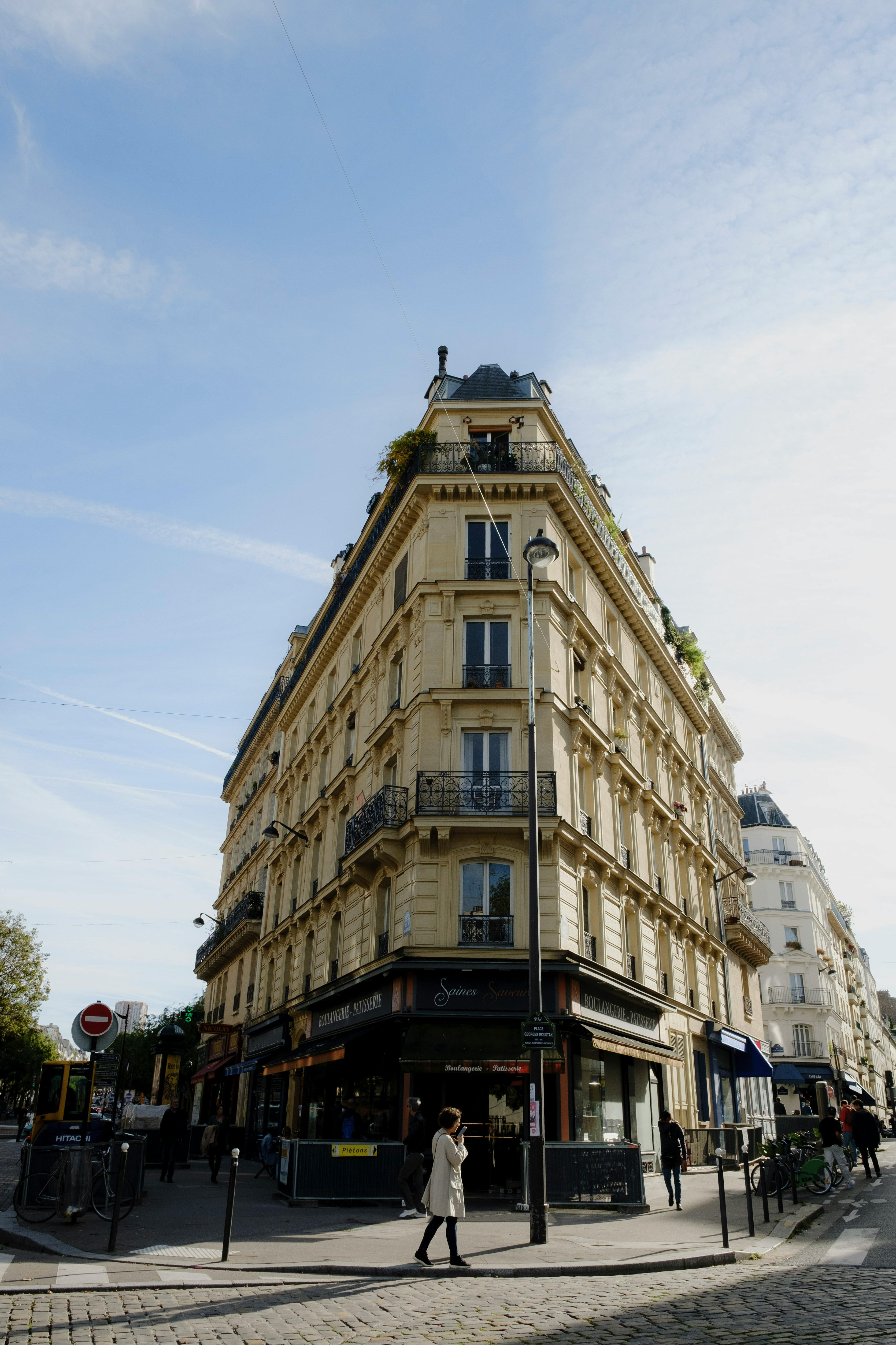 Free Captivating view of a classic Parisian corner building under a bright blue sky. Stock Photo