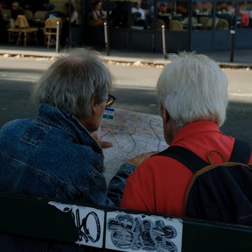 Back View of Senior Men Looking at a Map on a Street