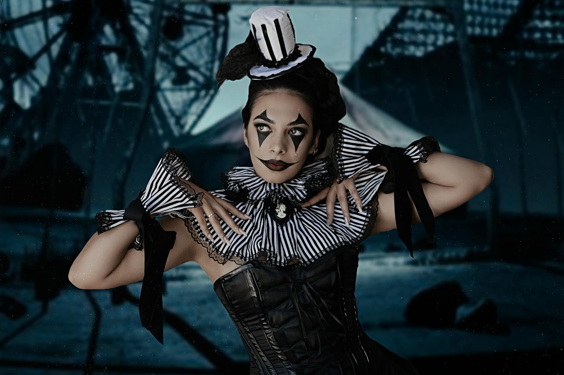 Captivating circus performer in striped black and white costume with dramatic makeup and mini top hat.