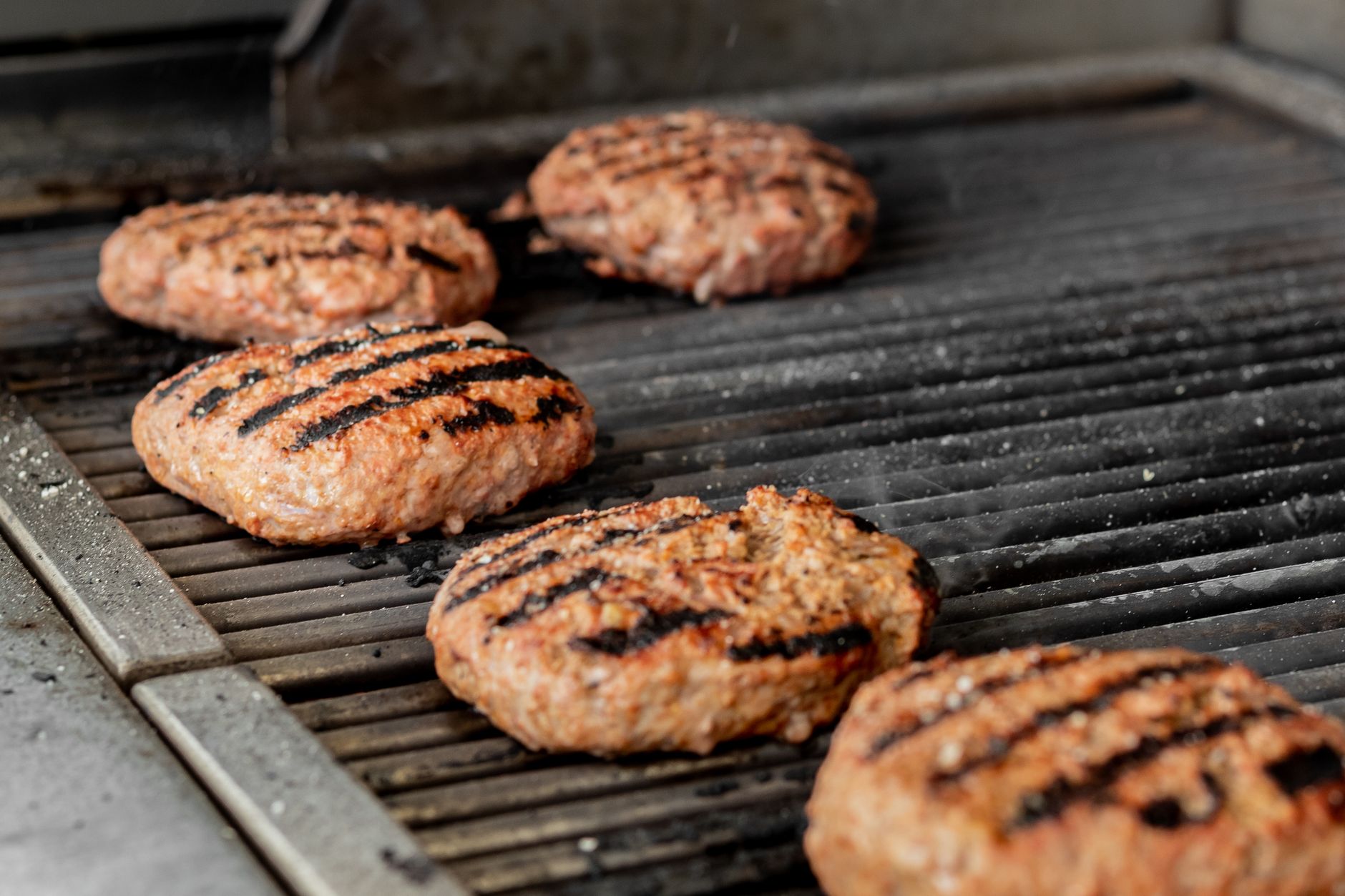 Close-up of grilled lamb patties cooking in a hot grill pan